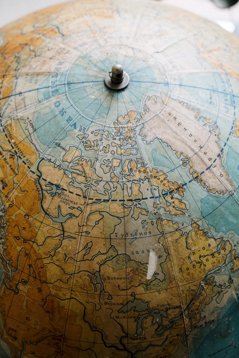 Detailed close-up of a vintage globe showing the Northern Hemisphere, highlighting Arctic regions.